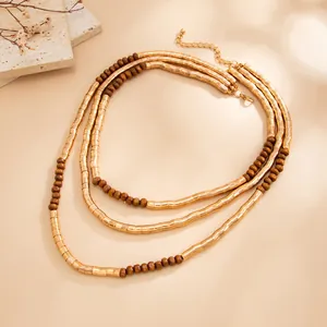 Detailed view of three-layer textured gold collar with brown wooden beads.