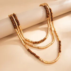 Detailed shot of textured metallic multi-layer necklace with brown wooden beads