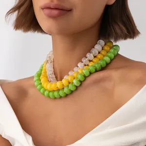 Close-up of three-layered bohemian resin bead necklaces in white, yellow, and green