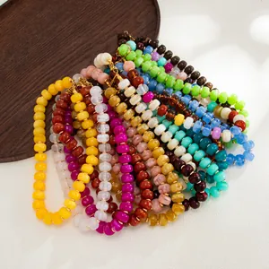 Macro view of colorful resin bead textures and swirling patterns in Bohemian necklaces.