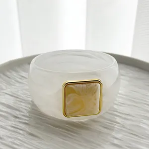 Close-up detail of retro white marbled resin bangle with square gold-toned inlay