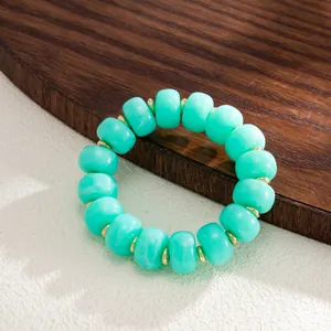High-quality detail of a turquoise swirled resin bead bracelet with golden metal spacers