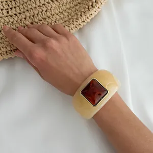 Close-up of vintage marbled resin bangle with a square amber-colored stone detail