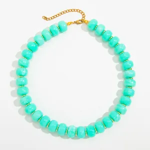 Close-up detail of bohemian turquoise resin beads and gold stainless steel chain.