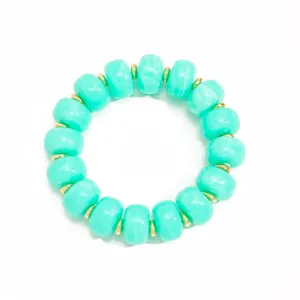 Detailed top-down view of a turquoise resin beaded necklace with gold spacers.