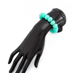 Detailed view of a bohemian turquoise resin beaded bracelet displayed on a black hand model