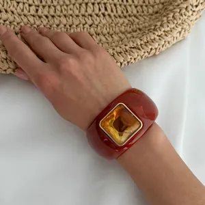 Detailed macro view of a retro terracotta resin cuff bracelet with amber square stone
