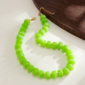 Close-up detail of vibrant green marbled resin beads on a bohemian stainless steel necklace