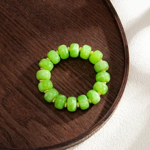 Detailed close-up shot of Bohemian marbled green resin beaded jewelry on wood tray