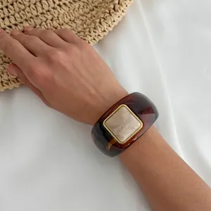 Close-up of retro tortoiseshell resin cuff bracelet with square marble inlay on wrist