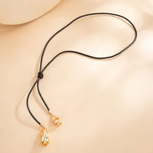 Adjustable black wax cord necklace featuring two irregular golden teardrop pendants.