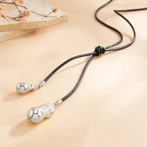 Detail of minimalist Y-shaped knotted necklace with irregular silver teardrop pendants