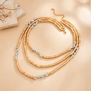 Detailed view of a multi-layer necklace with gold and silver metallic beads and tubes