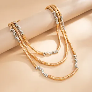 Close-up of textured gold and silver multi-layer metallic bead necklace detail