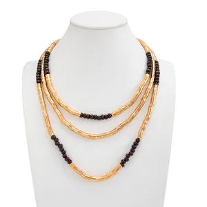 Three-layer gold metallic necklace with dark brown beads displayed on white mannequin