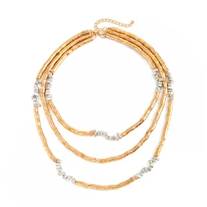 Close-up detail of three-layer metallic gold and silver textured bead necklace