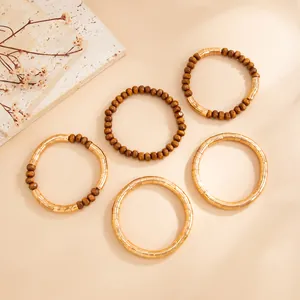 Detailed top view of vintage gold textured bangles and brown wooden beaded bracelet set