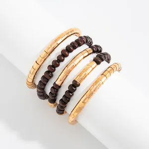 Detail view of multi-layered textured gold metal choker with dark brown beaded necklace
