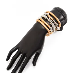 Stackable mixed metal beaded bracelets displayed on a black mannequin hand model