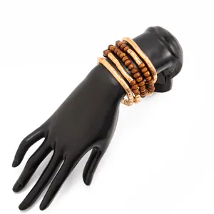 Close-up detail of stackable beaded bracelets featuring gold metal and brown wood beads