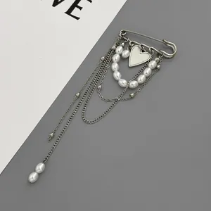 Multi-layer chain brooch with faux pearls and heart pendant in silver finish.