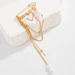 Close-up detail of faux pearl strings and golden heart pendant on this stylish chain brooch.
