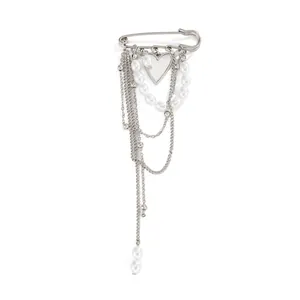 Detailed view of elegant silver chain brooch with heart pendant and white faux pearls