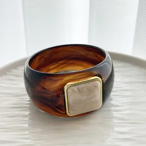 Detail view of a vintage tortoiseshell resin bangle with square marble centerpiece.