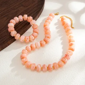 Detailed macro view of peach swirled resin beads with gold stainless steel spacers