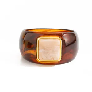 Close-up of vintage tortoiseshell resin bangle with square marbled inlay in gold frame