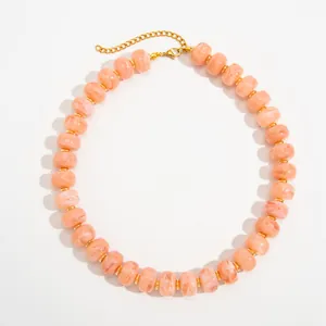 Close-up of bohemian peach marbled resin bead necklace with gold stainless steel spacers.