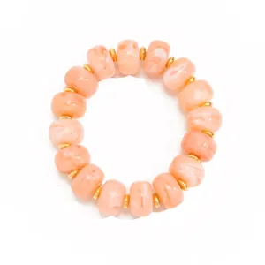 Detail view of Bohemian resin beaded necklace with peach marble swirl and gold spacers
