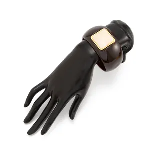 Retro brown resin cuff bracelet with cream square stone inlay on black hand model