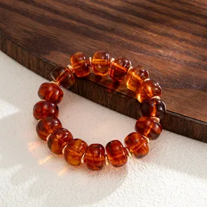 Close-up detail of Bohemian amber-swirled resin beaded bracelet on wooden background