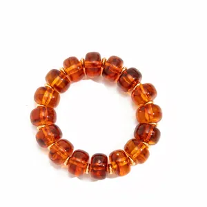 Close-up of amber-colored resin beads with gold-tone spacers on a white background.