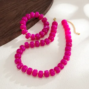 Detailed macro view of Bohemian magenta marbled resin beaded necklace and bracelet set