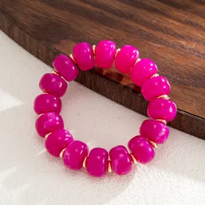 Vibrant magenta resin beaded bracelet featuring polished gold-toned metal spacers