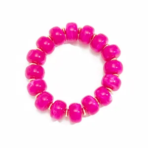 Macro view of fuchsia marbled resin beads with gold-toned stainless steel spacers