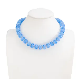 Detail view of blue marbled resin beaded necklace on white mannequin display.