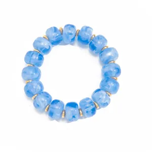 Detailed view of blue marbled resin bead bracelet with golden stainless steel spacers.