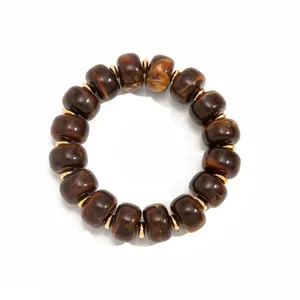 Detail view of bohemian resin bead necklace with amber marble effect and gold spacers