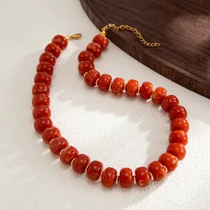 High-quality detail of bohemian marbled red resin bead necklace with gold spacers