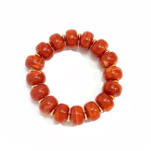 Detailed view of bohemian orange marbled resin bead bracelet with gold stainless steel spacers