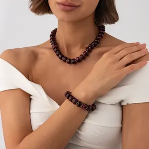 Close-up detail of Bohemian marbled red resin beaded necklace and bracelet set on a model