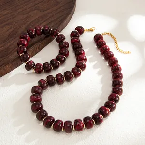Close-up detail of bohemian dark red marbled resin bead necklace and bracelet jewelry set