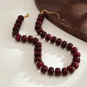 Detailed view of bohemian marbled red resin beads and gold stainless steel spacers.