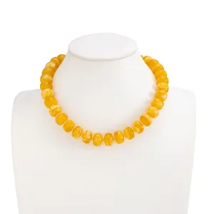 Detailed close-up of a yellow marbled resin beaded necklace on a white neck mannequin.