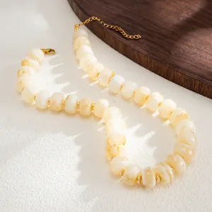 Close-up detail of bohemian marbled resin bead necklace with gold stainless steel