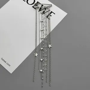 Detailed macro view of a silver-toned safety pin brooch with hanging star and chain charms.