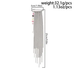 Detailed view of silver safety pin brooch with colorful zircons and long tassel chains